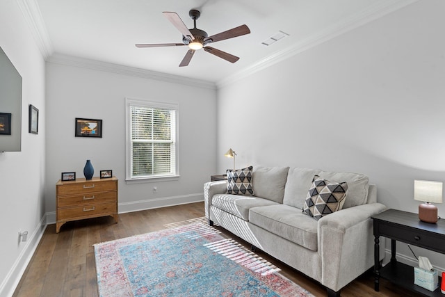 living room featuring ceiling fan, ornamental molding, and dark wood-type flooring