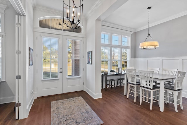 entryway featuring a chandelier, french doors, dark wood-type flooring, and ornamental molding