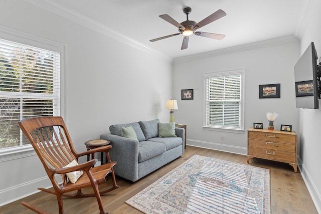 sitting room with light wood-type flooring, ceiling fan, and crown molding