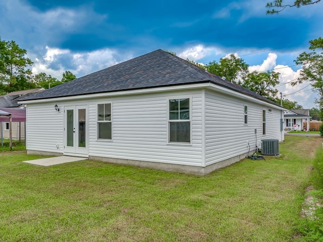 back of property with a yard, central AC, and french doors