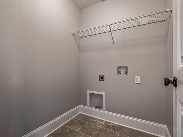 washroom featuring hookup for a washing machine, hookup for an electric dryer, and dark tile patterned flooring