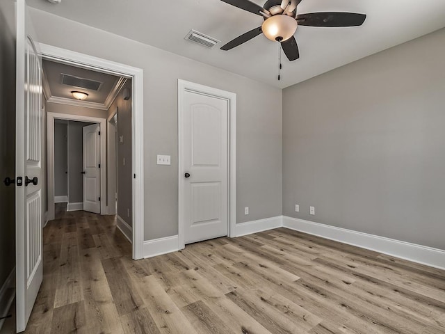 empty room featuring ceiling fan, ornamental molding, and light hardwood / wood-style flooring