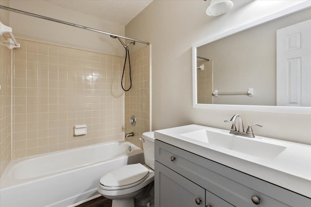 full bathroom featuring vanity, tiled shower / bath combo, and toilet