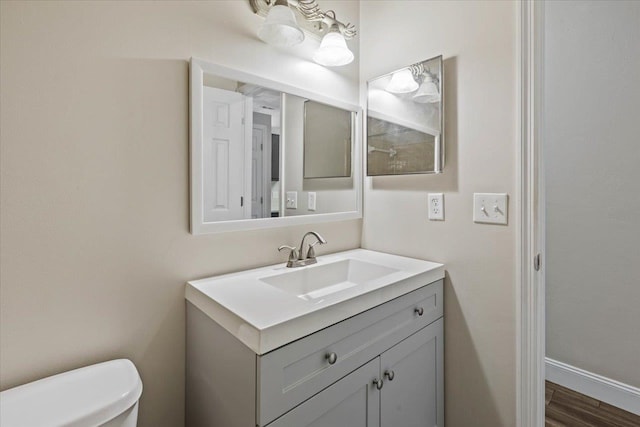 bathroom with hardwood / wood-style flooring, vanity, and toilet