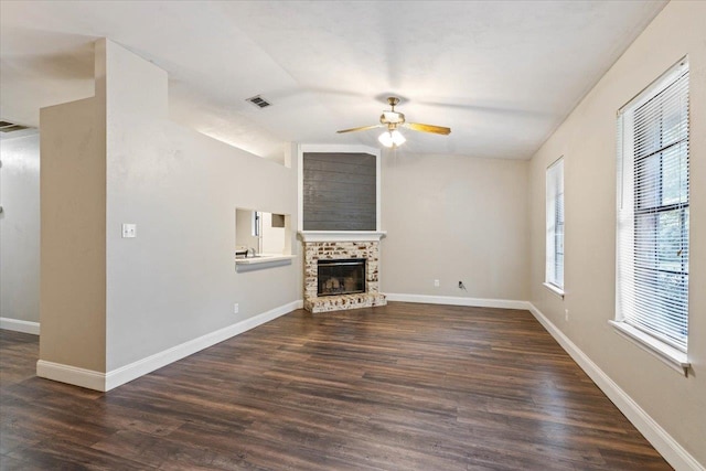 unfurnished living room with dark hardwood / wood-style flooring, ceiling fan, and a brick fireplace