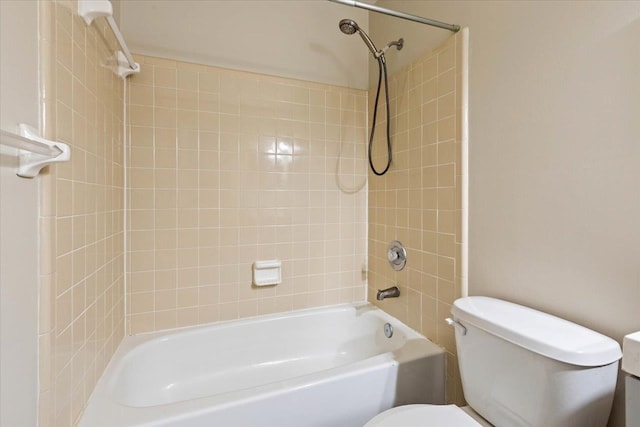 bathroom with toilet and tiled shower / bath combo