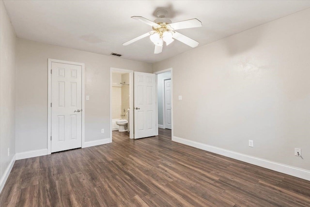 unfurnished bedroom with ensuite bathroom, dark hardwood / wood-style flooring, and ceiling fan