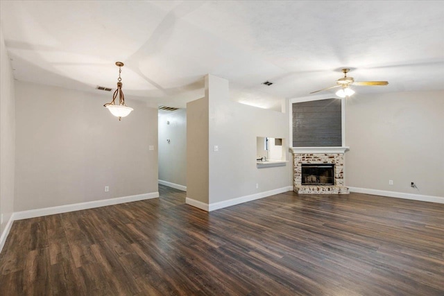 unfurnished living room with a tiled fireplace, dark hardwood / wood-style flooring, lofted ceiling, and ceiling fan