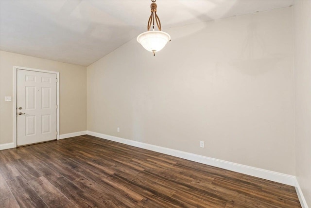 spare room with dark hardwood / wood-style flooring and lofted ceiling