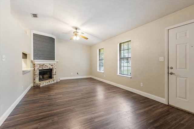 unfurnished living room with a brick fireplace, ceiling fan, and dark hardwood / wood-style flooring