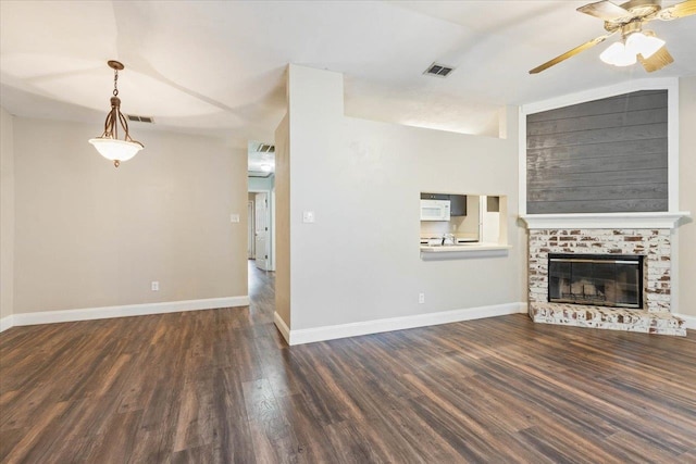 unfurnished living room with a brick fireplace, dark wood-type flooring, ceiling fan, and vaulted ceiling