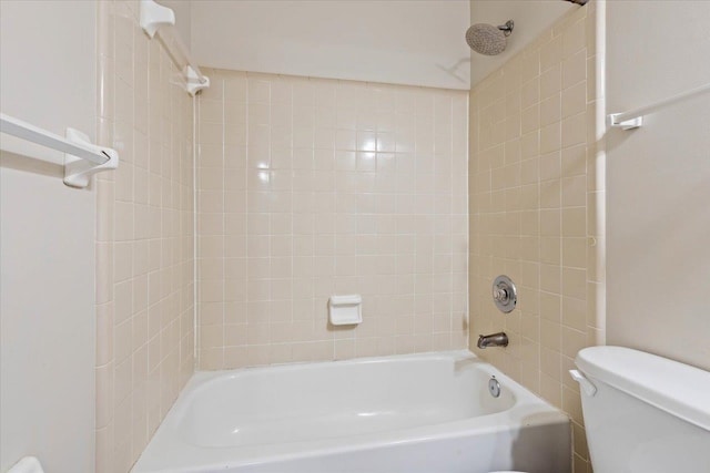 bathroom with toilet and tiled shower / bath combo