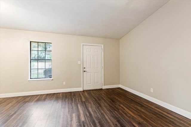 empty room with dark hardwood / wood-style floors and lofted ceiling