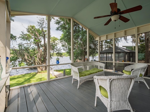 sunroom / solarium featuring a ceiling fan, plenty of natural light, and a water view