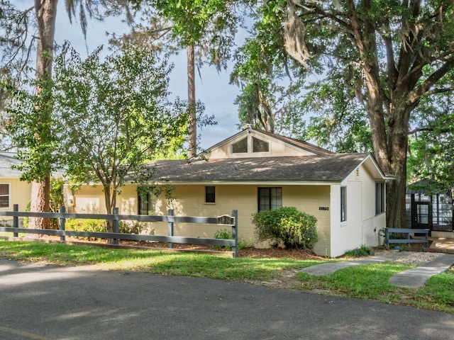 view of front of house featuring fence and a shingled roof