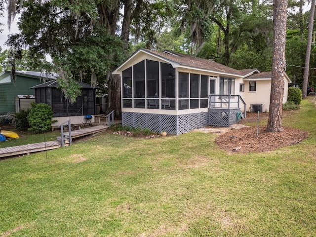 back of property featuring a yard and a sunroom