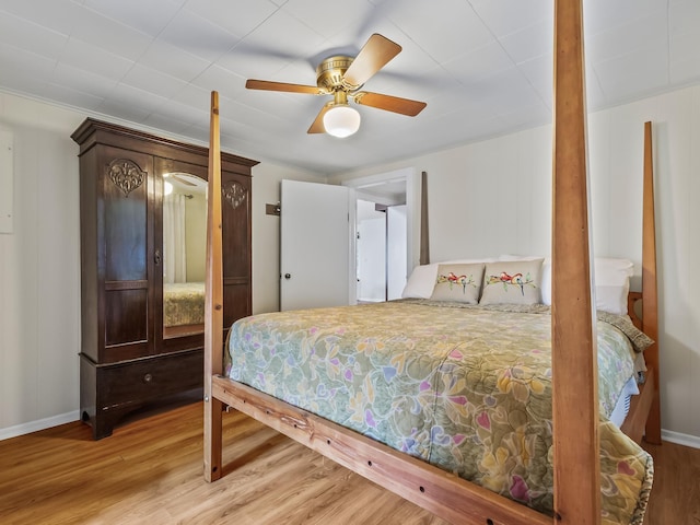 bedroom with a ceiling fan, baseboards, and wood finished floors