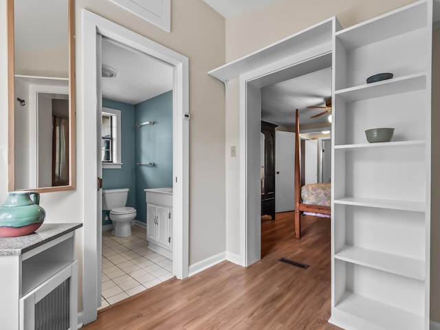 bathroom with ceiling fan, visible vents, wood finished floors, vanity, and toilet