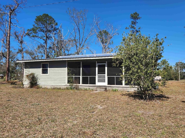 back of house with a sunroom and metal roof