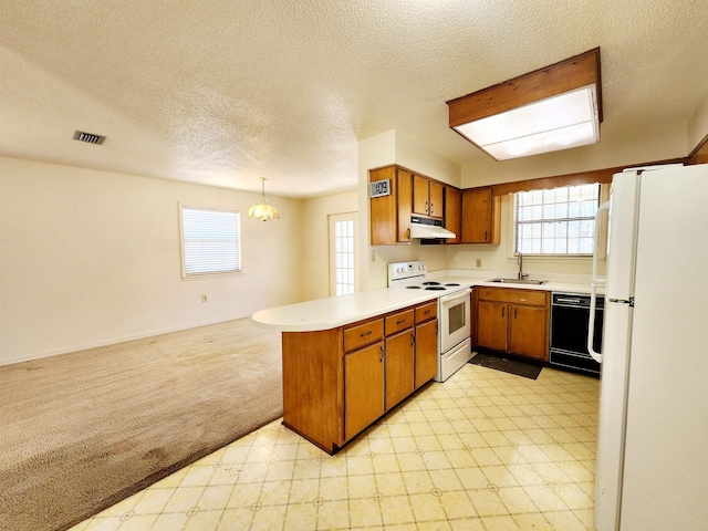 kitchen with under cabinet range hood, a peninsula, white appliances, a sink, and light floors