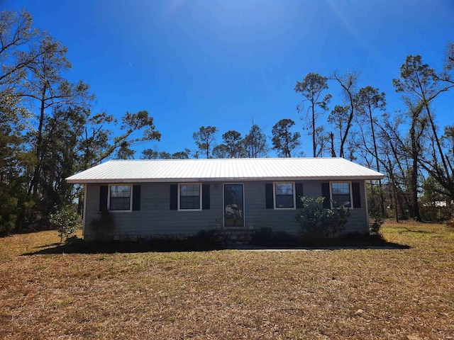 ranch-style house with metal roof and a front lawn