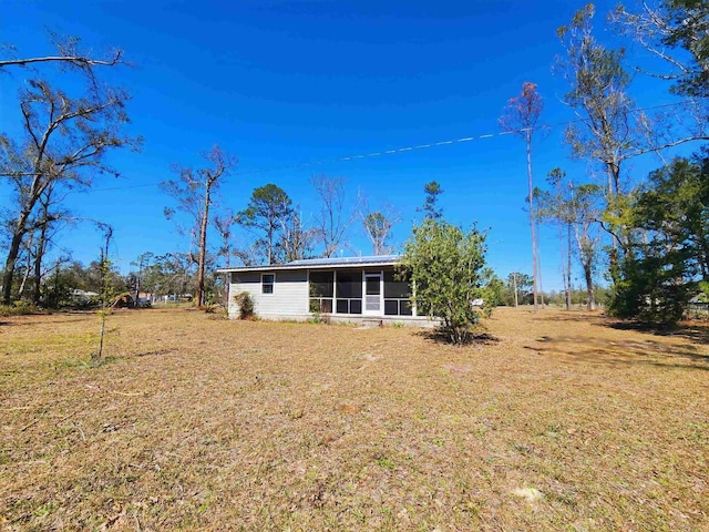 back of house with a lawn and a sunroom