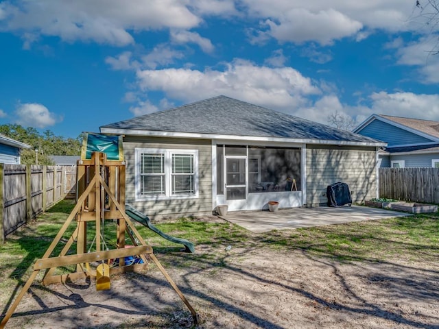 back of house featuring a playground and a patio