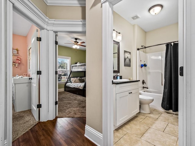 full bathroom with vanity, ceiling fan, toilet, hardwood / wood-style flooring, and shower / tub combo with curtain