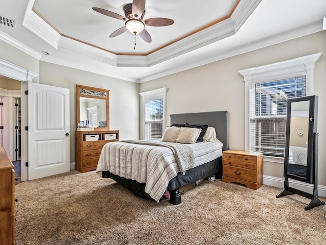 bedroom with ornamental molding, ceiling fan, a raised ceiling, and light carpet