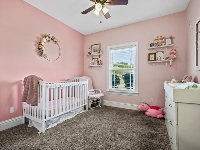 carpeted bedroom featuring ceiling fan and a nursery area