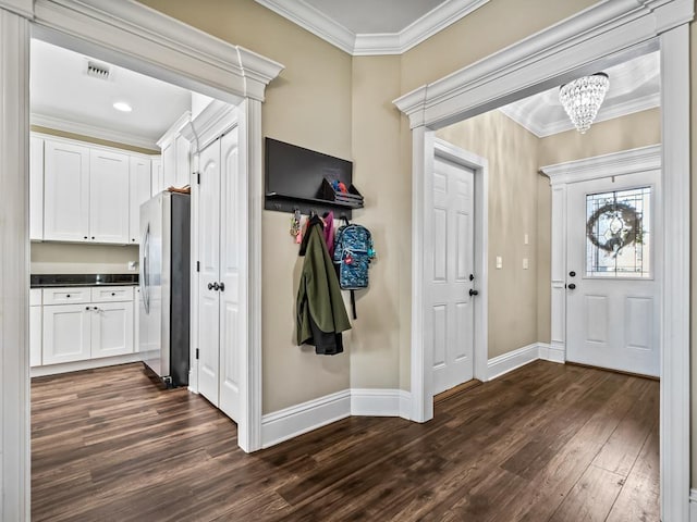 entrance foyer with a notable chandelier, crown molding, and dark hardwood / wood-style floors