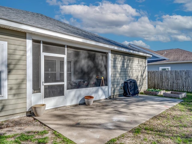 view of side of property featuring a patio and a sunroom