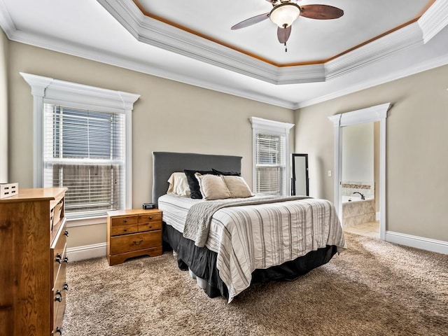 bedroom with ensuite bathroom, crown molding, light colored carpet, and a raised ceiling