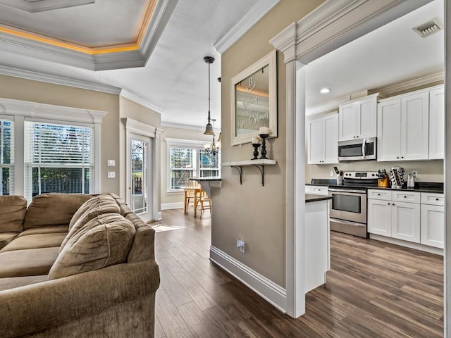 kitchen featuring stainless steel appliances, white cabinets, decorative light fixtures, ornamental molding, and dark hardwood / wood-style floors