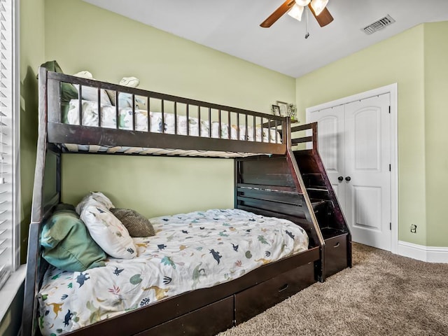 carpeted bedroom featuring a closet and ceiling fan