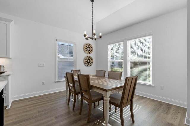 dining space featuring dark hardwood / wood-style flooring, a notable chandelier, and a healthy amount of sunlight