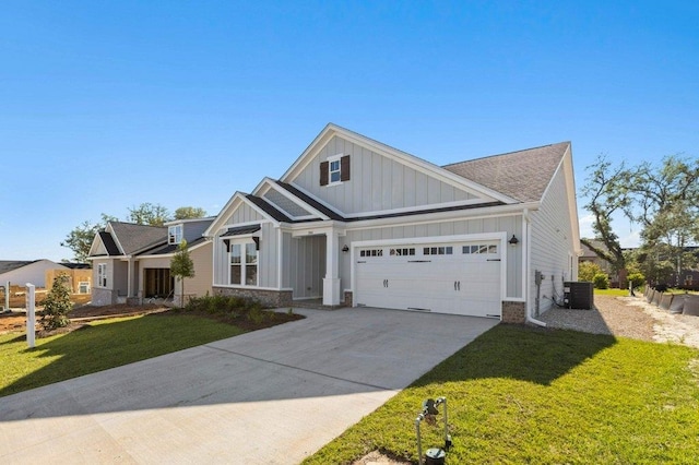 view of front of home with a garage, central AC, and a front yard