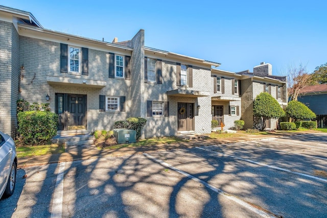 1625 Centerville Rd Unit 20, Tallahassee, FL 32308 - view of property with brick siding, uncovered parking, and a chimney