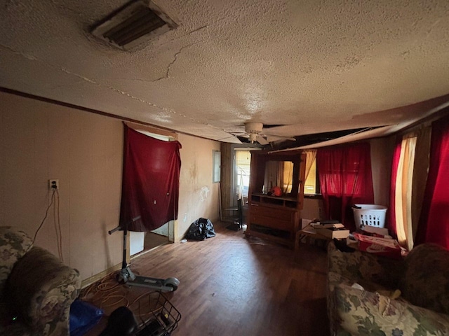 miscellaneous room with a textured ceiling, ceiling fan, and wood-type flooring