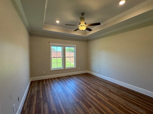 spare room with ceiling fan, dark hardwood / wood-style floors, crown molding, and a tray ceiling