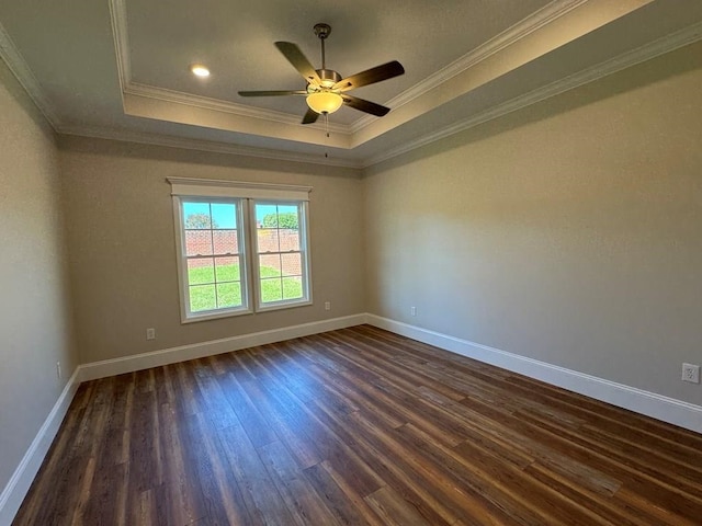 spare room with dark hardwood / wood-style flooring, ceiling fan, crown molding, and a tray ceiling