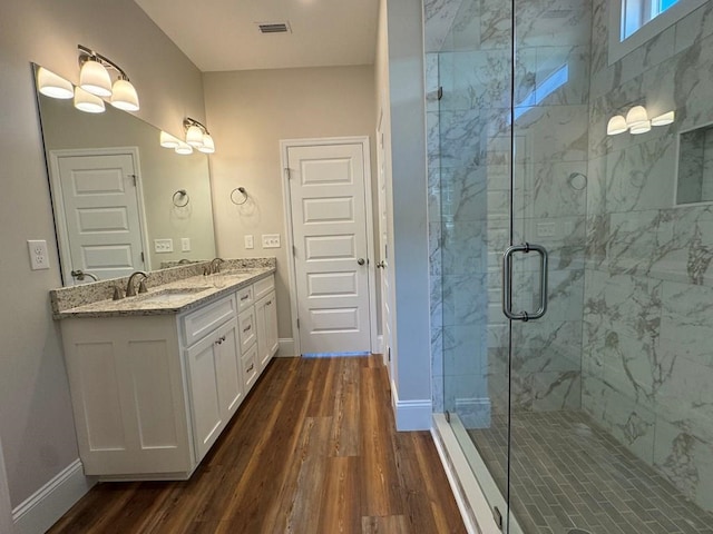 bathroom featuring wood-type flooring, vanity, and a shower with door