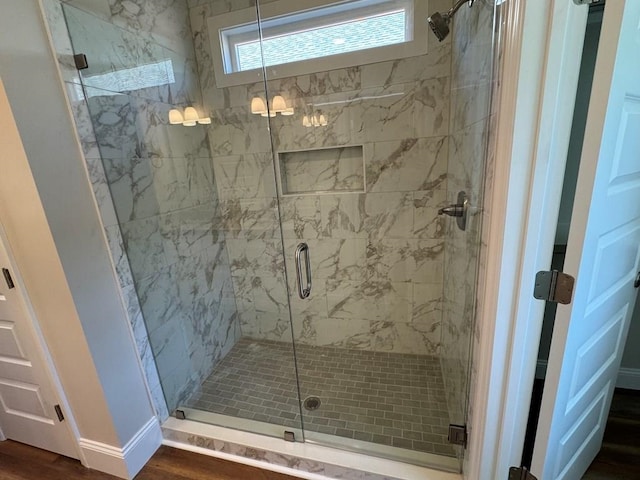 bathroom featuring hardwood / wood-style flooring and walk in shower