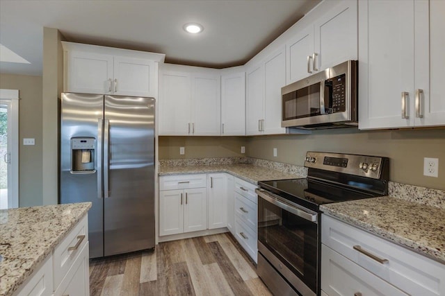 kitchen featuring light stone countertops, stainless steel appliances, light hardwood / wood-style floors, and white cabinets