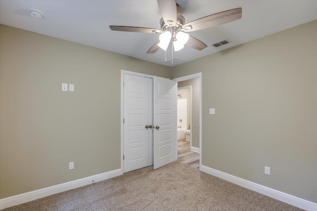 unfurnished bedroom featuring light colored carpet, ceiling fan, and a closet