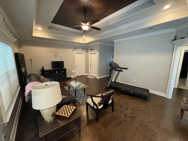 living area featuring crown molding, baseboards, ceiling fan, dark wood-style floors, and a raised ceiling