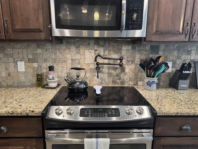 kitchen with backsplash, appliances with stainless steel finishes, and dark brown cabinetry