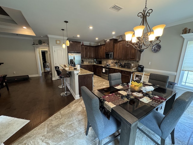 dining area featuring an inviting chandelier, ornamental molding, recessed lighting, and visible vents