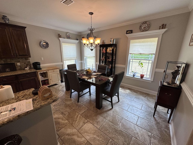dining area with visible vents, baseboards, a notable chandelier, ornamental molding, and stone tile floors
