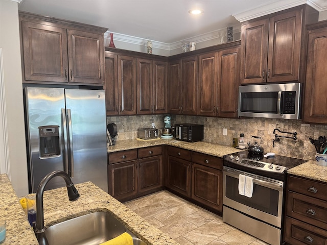 kitchen with backsplash, dark brown cabinets, and appliances with stainless steel finishes